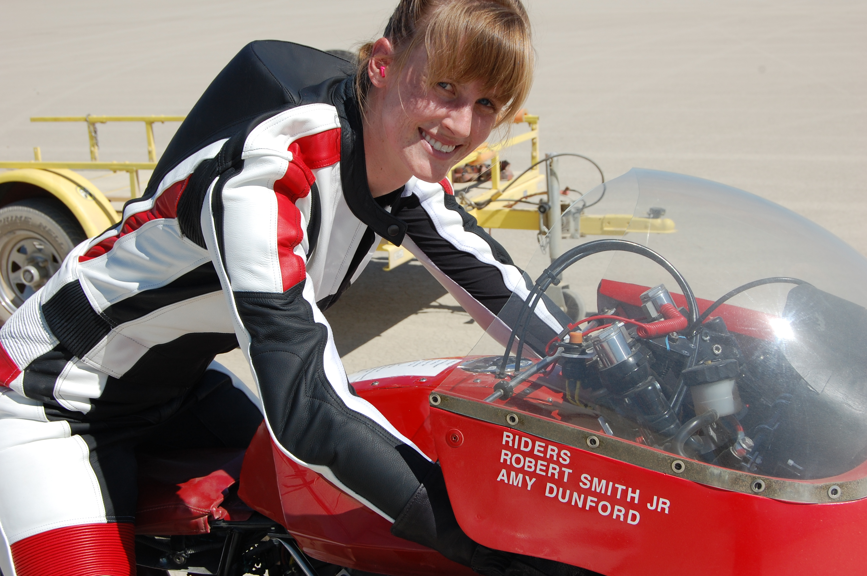 Amy warming up The Red Baron motorcycle, helmet off, at El Mirage