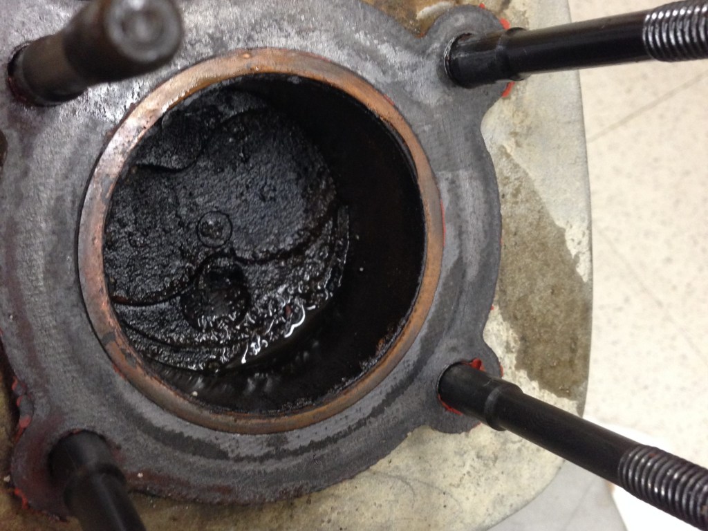 looking down into the cylinder, piston visible, all covered in sludge